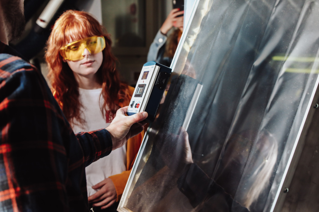 Person woman standing indoors laboratory for solar simulator protective glasses measuring equipment